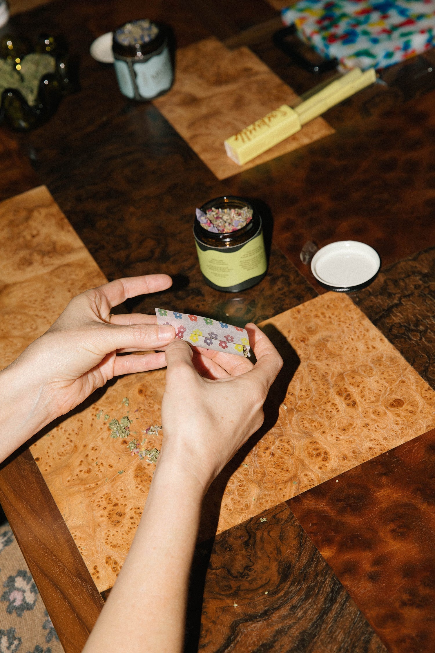 Functional wellness meets functional recreation - A person rolls a joint with Barbari herbal smoking blends and flower printed rolling papers.